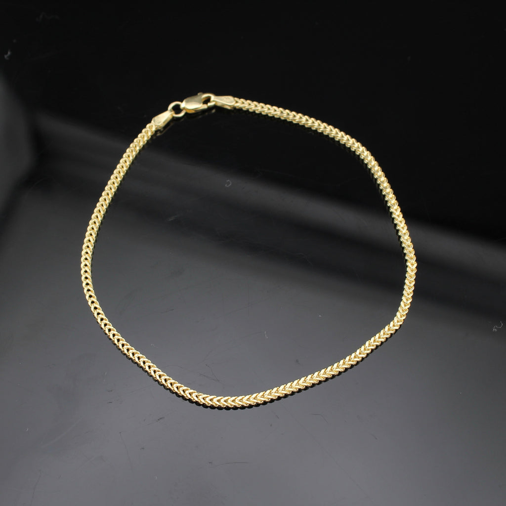 Gold chain bracelet on a dark background