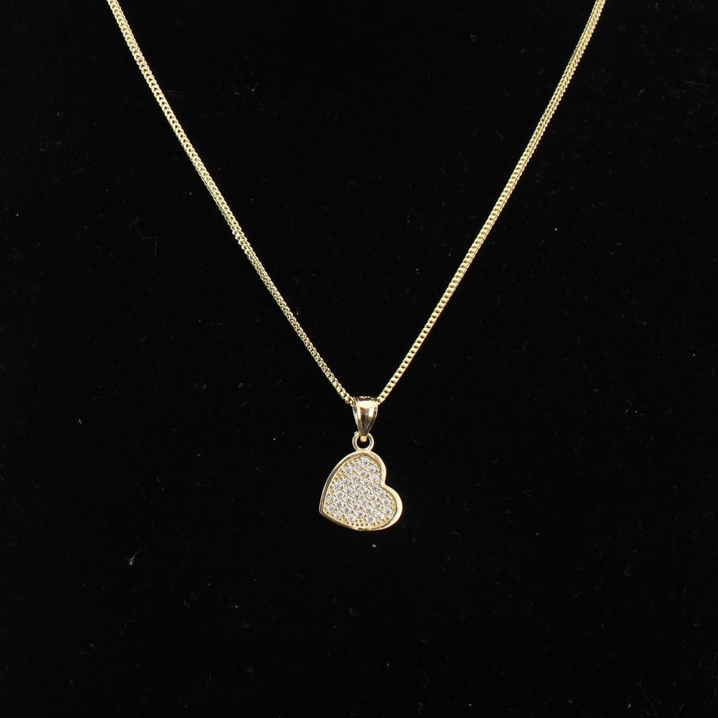 Gold necklace with a heart-shaped pendant on a black background